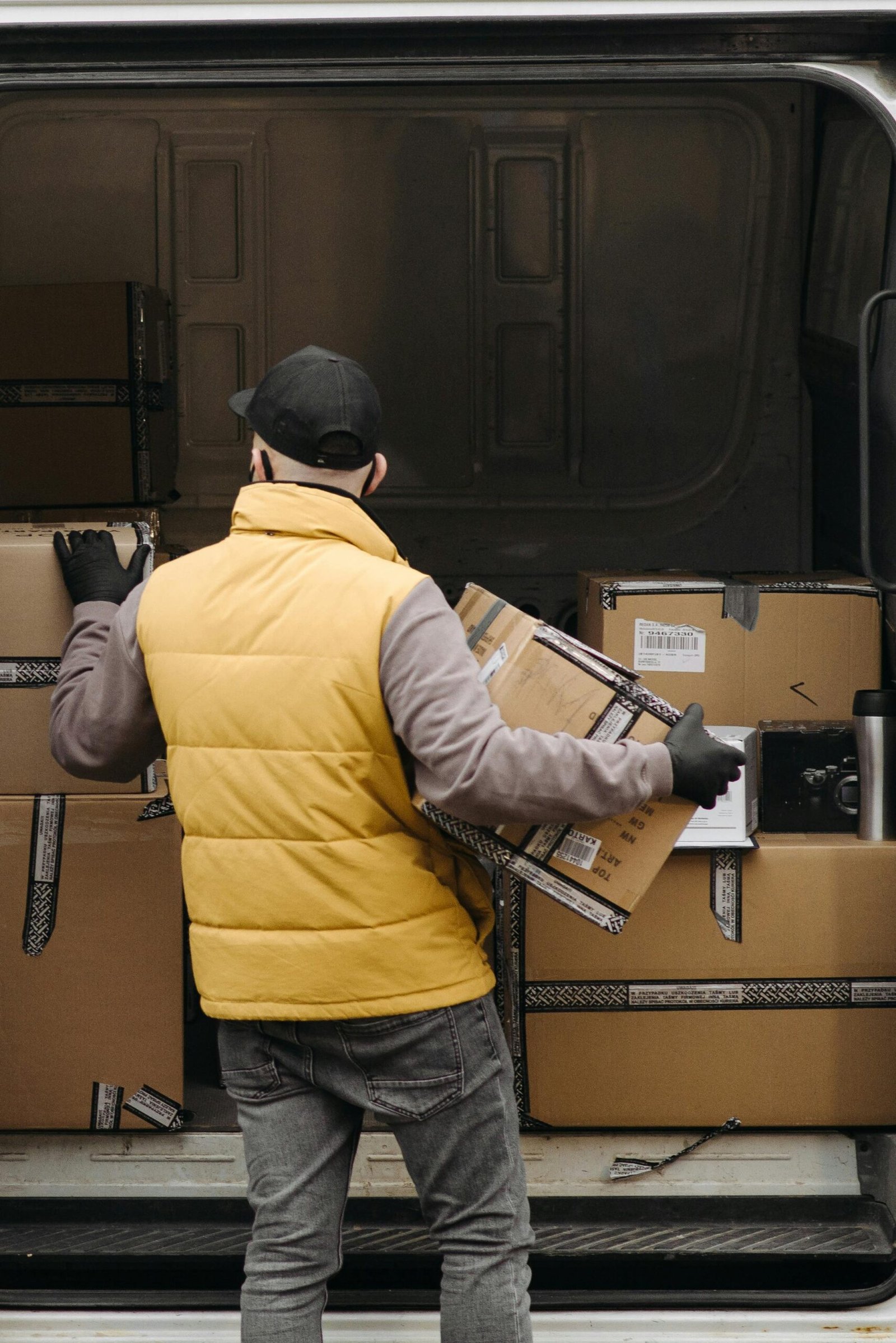 Deliveryman organizing packages into a van for distribution.